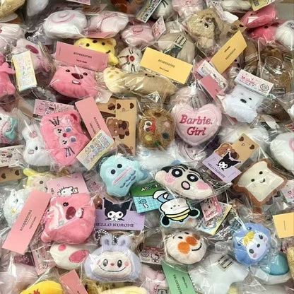 Colorful collection of plush doll keychains displayed in packaging, featuring various adorable designs and cartoon characters.