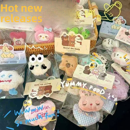 Collection of cute plush doll keychains displayed in packaging, showcasing animal-themed designs and vibrant colors.